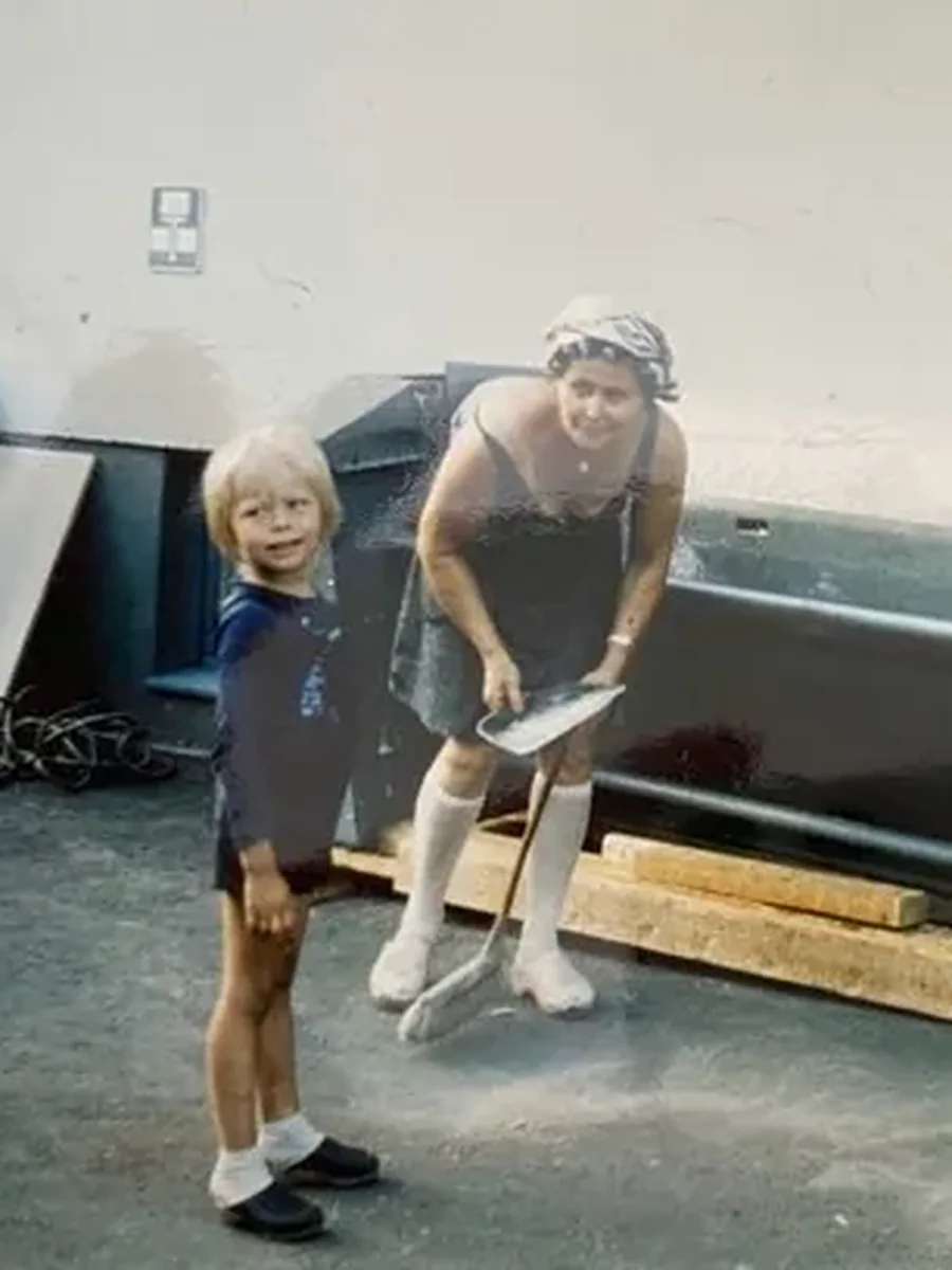 A woman and a small boy beside the ironer at the Rusanen laundry
