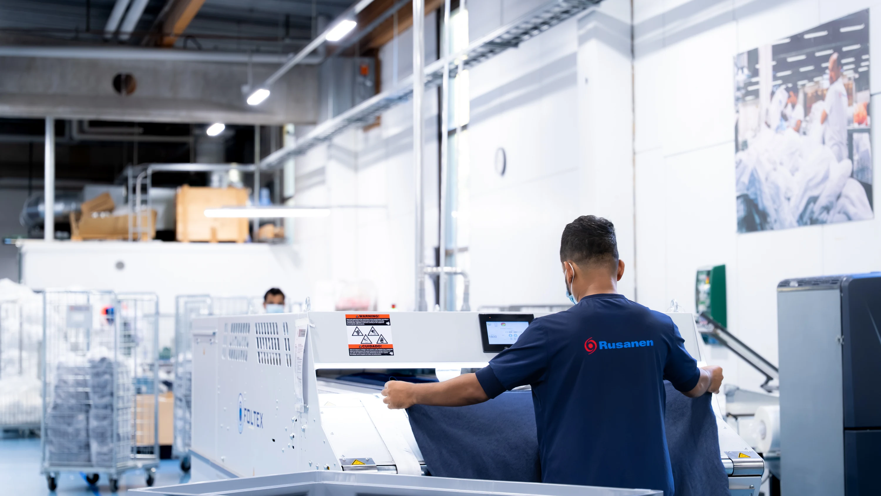 A Rusanen employee finishing workwear in our own laundry
